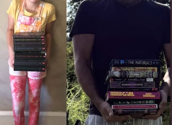 Brian and his daughter each holding a tall stack of books